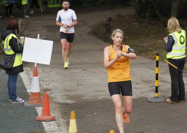 Michelle Tickle checks her watch at the end of the Lytham Hall parkrun
