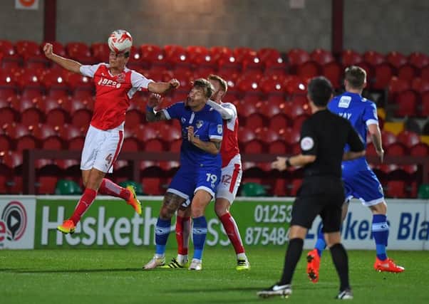 Fleetwood Town's Eggert Jonsson gets to the ball first against Oldham