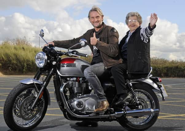 Katie Crabtree, 78. rides on a motorbike with Carl Fogarty as part of her bucket list organised by community group Just Good Friends