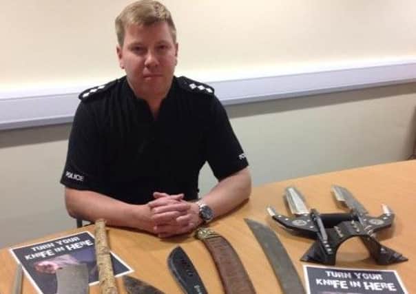 Chief Inspector Mark Baines and some knives that have previously been seized by police.