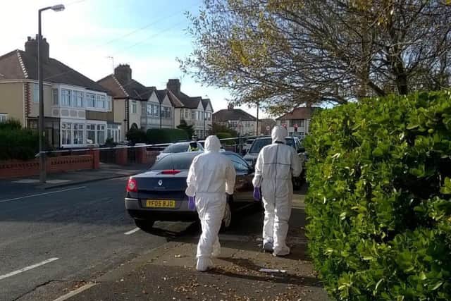Forensics officers have been seen scouring the street for evidence