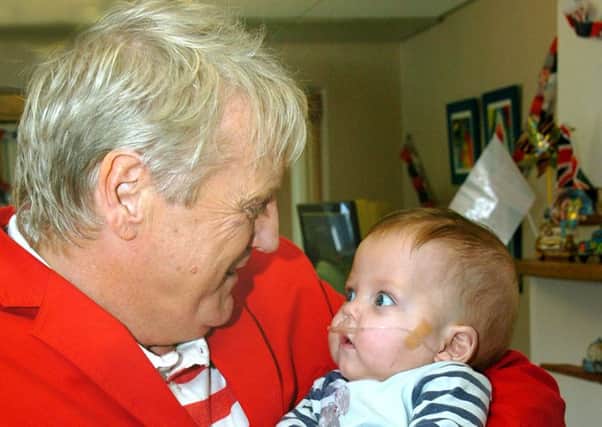Entertainer Joe Longthorne at Brian House Children's Hospice with tragic Charlie, who was 10 months' old at the time