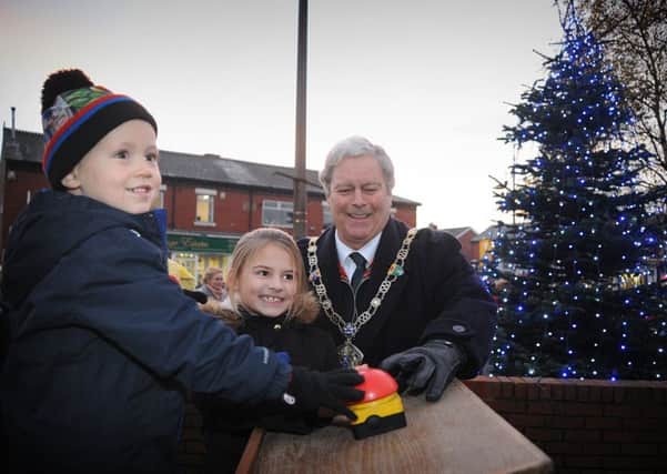 The Mayor of Wyre Councillor Terry Lees is assisted by prizewinners Alex Ayres and Olivia Clueit to officially switch on the lights