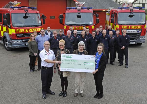 Firefighters and staff from the Kings Arms in Garstang hand over money raised in a football match and auction to Trinity Hospice.  Pictured L-R are station manager Colin Hickson, Maxine Metcalfe, Renee Metcalfe and Emma Padgett from Trinity.