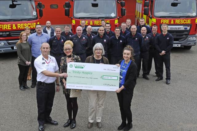 Firefighters and staff from the Kings Arms in Garstang hand over money raised in a football match and auction to Trinity Hospice.  Pictured L-R are station manager Colin Hickson, Maxine Metcalfe, Renee Metcalfe and Emma Padgett from Trinity Hospice