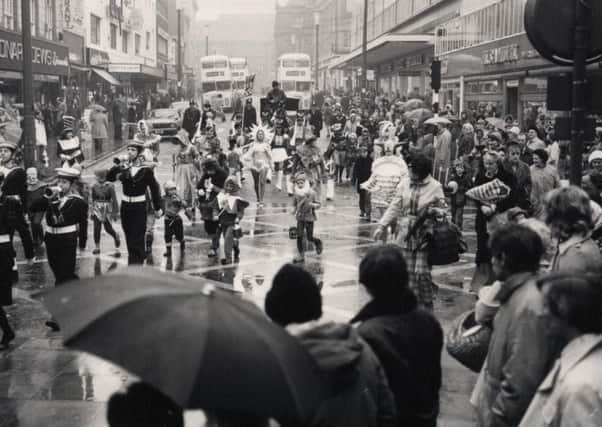 Crowds watch the annual procession of Father Christmas on his way to RHO Hills store in the rain, through Blackpool in 1975