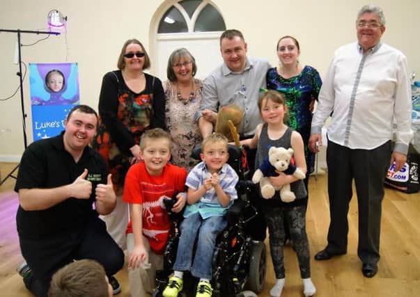Luke Carter (middle), Josh Carter (left of Luke) and the Brewin family after a New Year's Eve party which raised Â£2,000 towards Luke's SDR surgery.