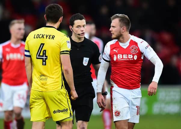 Referee Darren England speaks to Bristol Rovers' Tom Lockyer and Fleetwood Town's David Ball