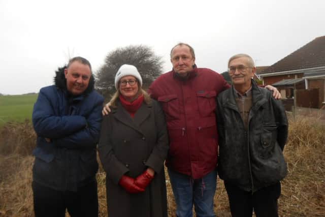Members of the Garstang and Knott End Light Railway group at Hackensall Crossing, Knott End, with the part of the route to Knott End behind them