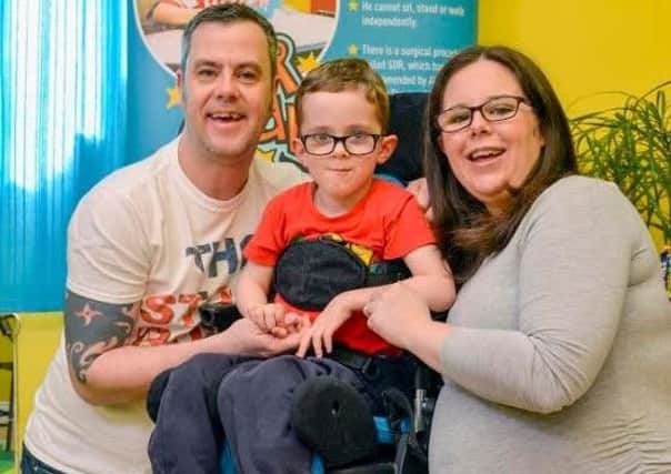 The Hudson family Lee, Thomas and Joanne from Cabus, near Garstang, celebrate raising enough money to book Thomas' SDR surgery.