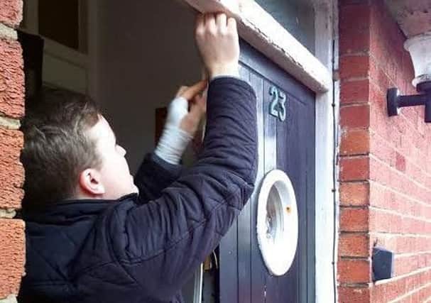 Blackpool Carers' Centre volunteer Daniel Foster fitting door insulation at a carer family house