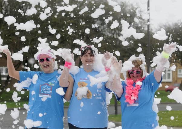 Staff and volunteers at Brian House get ready for the Bubble Rush with a practice session.  L-R are Toni Isaksen, Vicki Murphy and Sue Pelling.
