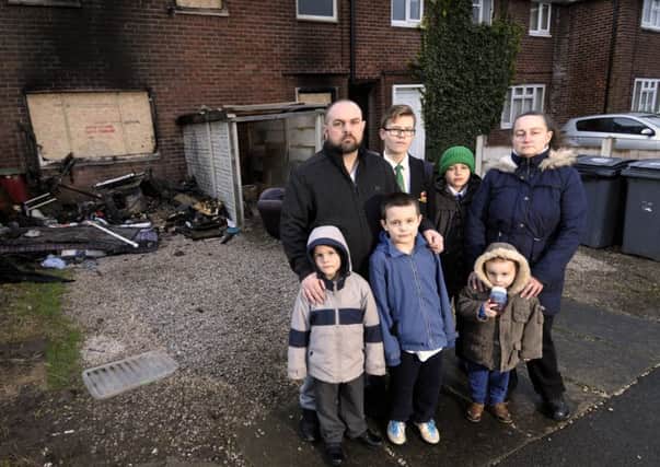 The Walwyn family outside their home which was badly damaged by fire.  Pictured  clockwise from left is dad Graham with Jack, Adam, wife Sam, Tyler, Lucas and Mason.