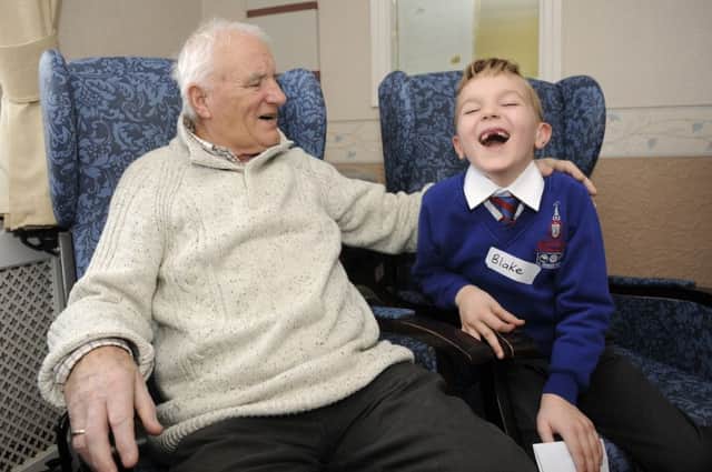 Children from Bispham Endowed Primary School visit residents at Glen Tanar Care Home.  Robert Brooks shares a joke with seven-year-old Blake Shilton.