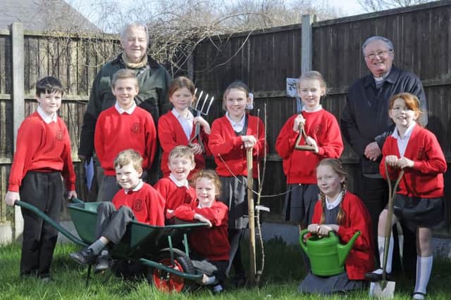 Pupils at St John's Primary School have been planting trees.  Some of them are pictured with John Turner and Father John Walsh.