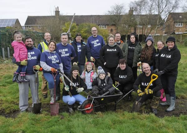 Members of Mereside MAFIA and staff from William Hill help clean derelict land for a new orchard