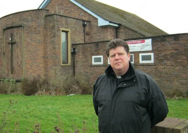 Father John Hall in front of the boarded-up St David's Church in Fleetwood.
