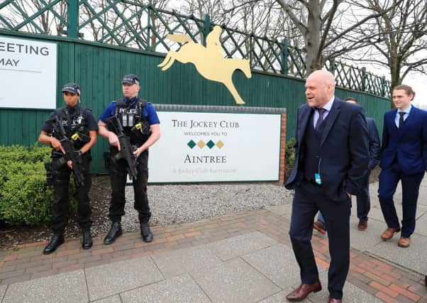 Armed police officers are present as racegoers arrive during day one of the Randox Health Grand National Festival at Aintree