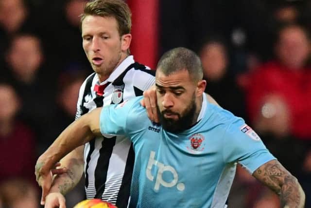Blackpools Kyle Vassell shields the ball from Grimsby Towns Danny Collins during Decembers goalless draw