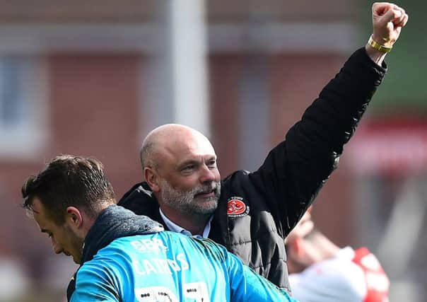 Fleetwood Town manager Uwe Rosler celebrates with Alex Cairns