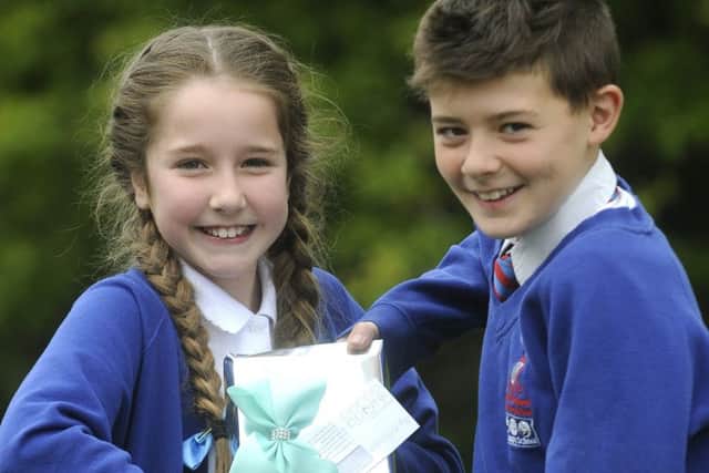 Ten-year-old Amy Ellis  giving a gift to 11-year-old Lennon Smith