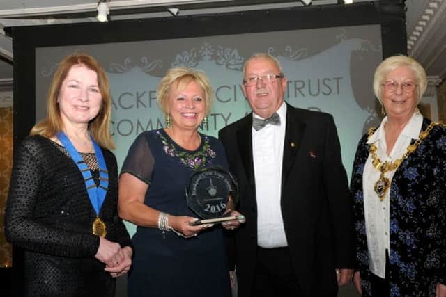 Shirley Hunt and Gary Pretty (centre) with the Community Award presented to the Friends of the Illuminations