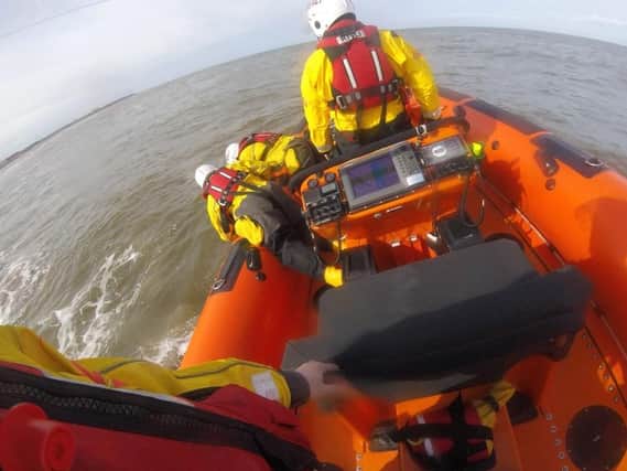 Lifeboat crews pull the man from the water