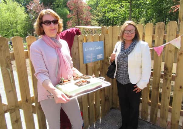 Sue Lowe, volunteer coordinator at Lytham Hall, and Emma Barrett, manager of the Lytham branch of Tesco Express,  with celebratory cake at the official opening of the Hall's kitchen garden