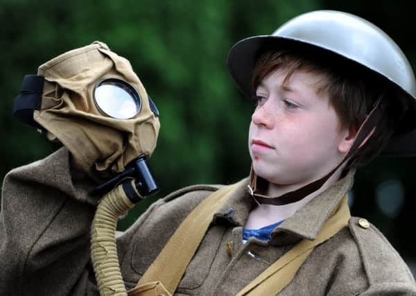 Austin Clutterbuck tries on the uniform and gas mask at a previous First World War event