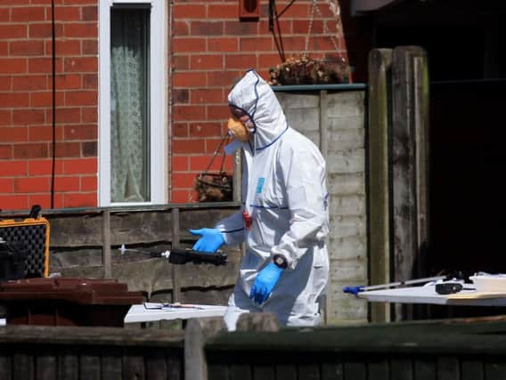 A police forensic investigator at an address in Elsmore Road, Greater Manchester
