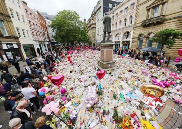 People look at flowers and tributes left in St Ann's Square in Manchester, exactly a week since the Manchester Arena terror attack took place. PRESS ASSOCIATION Photo. Picture date: Monday May 29, 2017. See PA story POLICE Explosion. Photo credit should read: Owen Humphreys/PA Wire