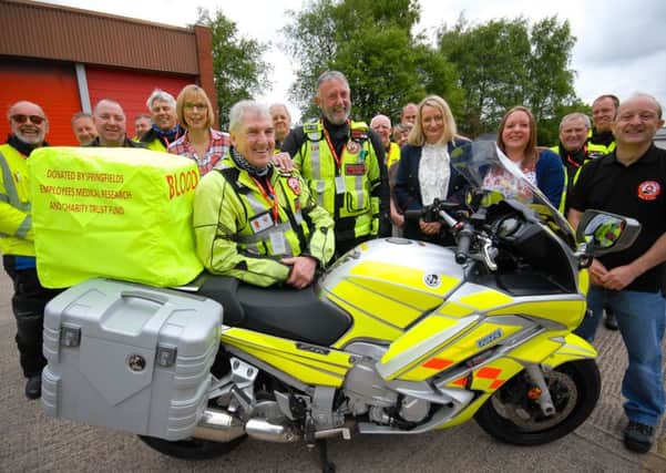 Volunteers from the North West Blood Bikes collect the box covers from members of the Charity Trust Fund at Springfields