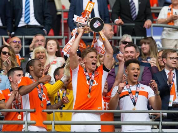 Blackpool chief executive Alex Cowdy, right, celebrates as Brad Potts lifts the trophy