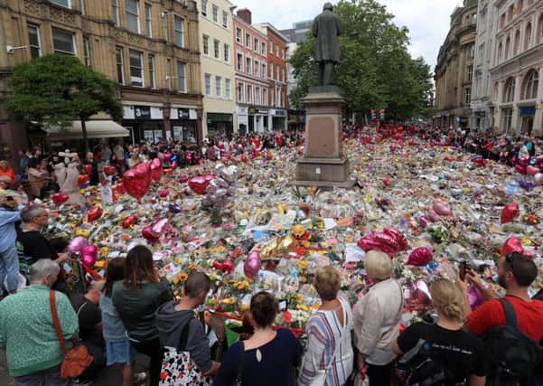 People look at flowers and tributes left in St Ann's Square in Manchester following the Manchester Arena terror attack. PRESS ASSOCIATION Photo. Picture date: Saturday June 3, 2017. See PA story POLICE Explosion. Photo credit should read: Danny Lawson/PA Wire