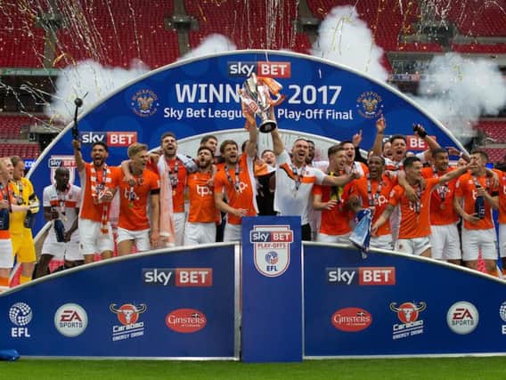 Aldred lifts the League Two play-off final trophy at Wembley