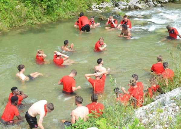 The Fleetwood Town players cool off in a stream in Austria. Photo credit FTFC