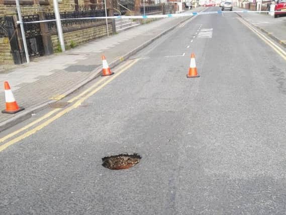 A hole lot of trouble: Police have taped off Adelaide Street after a small hole appeared in the road