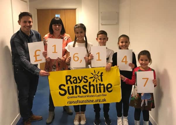Claire Pinder (second left), with her family and the final total they raised with their charity ball for Rays Of Sunshine