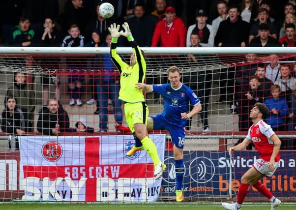 Fleetwood Town's Alex Cairns saves under pressure from Carlisle United's Mark Ellis