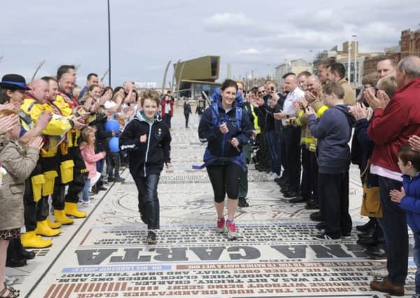 11-year-old Alex Davis running with paramedic Rebecca Healer at the torch's launch in April