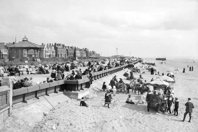 the north promenade and beach with holidaymakers in st annes-on-sea. a kiosk has been set up to sell ice-cream and donkeys are made ready to take children up and down the beach. a bandstand lies to the left of the photograph. lancashire fylde lytham st annes
