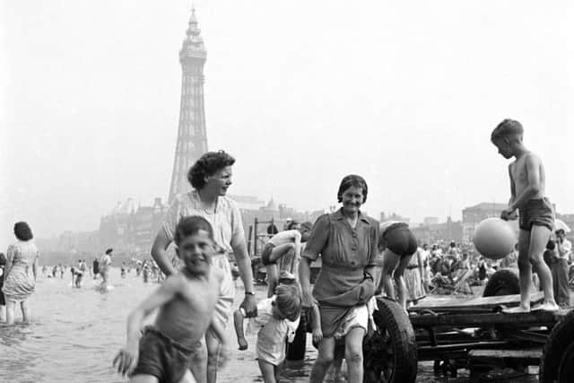 Playing in the sea in the shadow of Blackpool Tower   Photo: John Gay/Historic England/Mary Evans