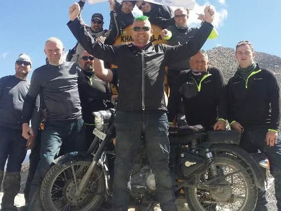 A group photo of the Lancashire Police team at the top of the Khardung La Pass after their motorcycle challenge for the AWARE charity