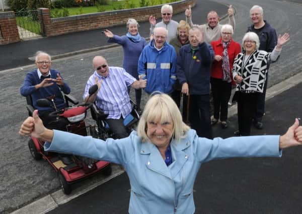 Residents on Kirkstone Avenue are celebrating after their pavements were finally repaired.  Pictured is Pam Barrow with other residents.