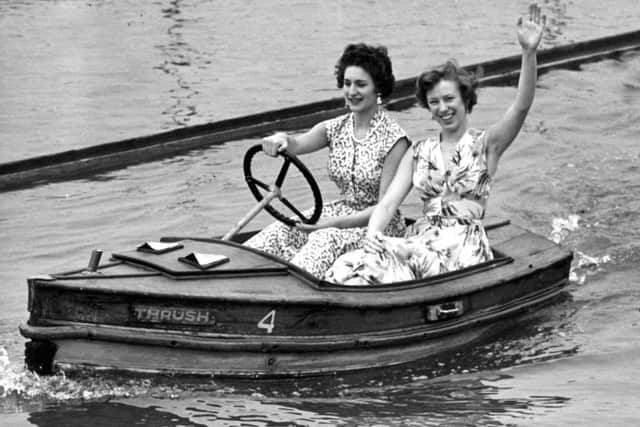 Two women enjoy sailing a boat on Fairhaven Lake in the 1950s