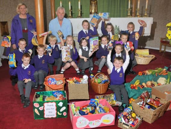 Children from St Wulstan's and St Edmund's Catholic Primary School with some of the produce they collected for their Harvest Festival.