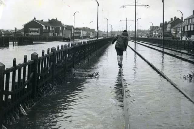 Tip-toe down the tram track, a precarious pastime in Anchorsholme Lane, Cleveleys after the November floods, in 1977