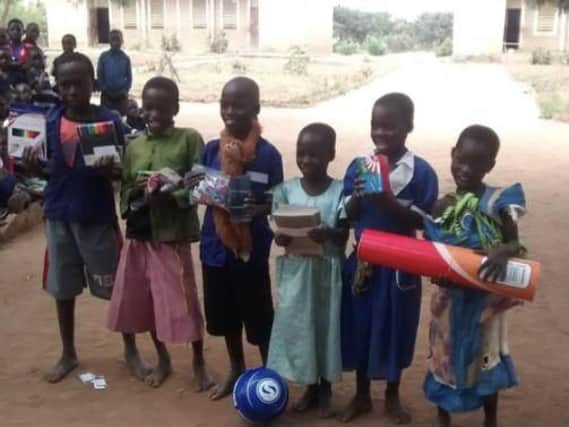 Children in Malawi gratefully deceive donated gifts, including footballs from BJFF