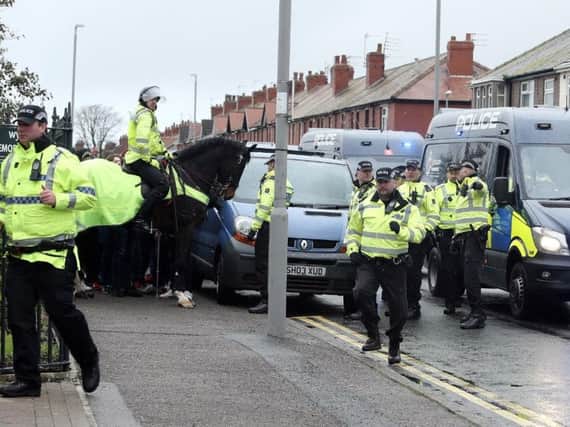Lancashire police escort a section of the travelling Blackpool supporters into Fleetwood's Highbury stadium