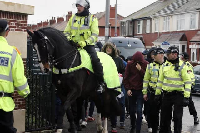 Blackpool fans are escorted into Fleetwood's Highbury Stadium by the police